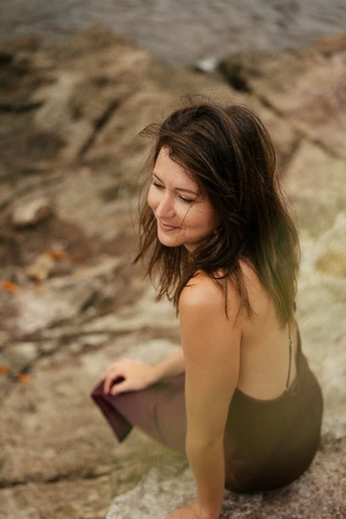 Sarah Teillard assise au bord de l'eau en Martinique